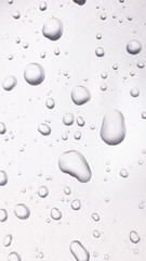 dots of water on light metal surface, macro background, vertical shot