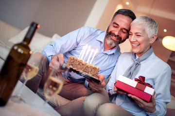 Happy mature couple celebrating at home