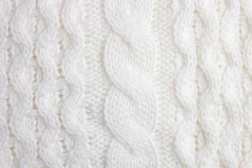 White knitted sweater texture as background. Knitted pattern. Top view. Macro view
