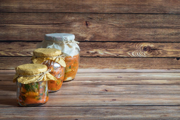 Korean kimchi in jars on a dark wooden table.