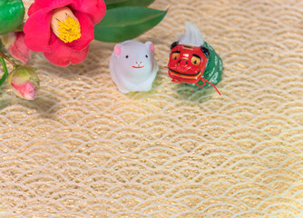 A Japanese greeting card with a Tsubaki flower also called the winter rose and a Folklore animals figurines depicting a Shishimai lion and a cute rat figurine for the 2020 year of the mouse