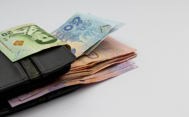 Many Thai banknotes in a wallet placed on a white background. Concept interpretation of means to expand Whether saving money or investing For the growth to grow even more For stability in the future