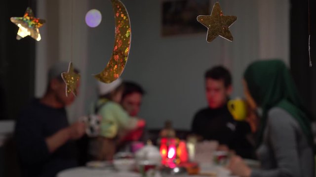 Muslim family eating festive dinner at home. Mawlid or Mawlid al-Nabi al-Sharif is the observance of the birthday of Islamic prophet Muhammad