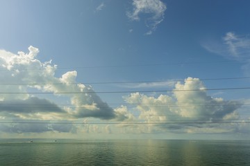 Gorgeous view of Atlantic ocean. Mirror water surface merging with blue sky with white clouds. Two...