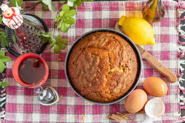 Homemade sponge cake and its ingredients, flour, eggs, sugar, olive oil, cinnamon and lemon