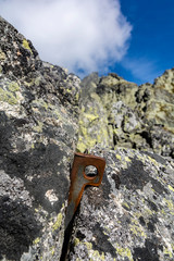 Piton (angle - V shape) placed in a rock crack for safety when climbing. In the background a...