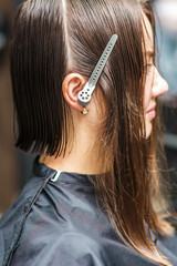 Fototapeta premium Young woman with wet or oily hair on a beauty salon side view. Hair salon, beauty spa. Procedure of hair extensions.