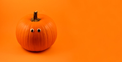 Cute Halloween pumpkin with googly eyes stock images. Halloween pumpkin with googly eyes on a orange background. Halloween pumpkin on a orange background with copy space for text