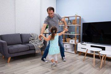 Father Dancing With Her Daughter At Home