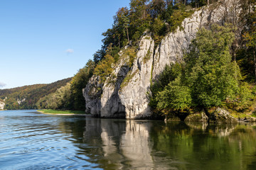 Fototapeta na wymiar Danube river near Danube breakthrough near Kelheim, Bavaria, Germany in autumn with limestone rock formations and sunny weather with blue sky