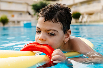 niño jugando terapia en piscina con tubo flotador