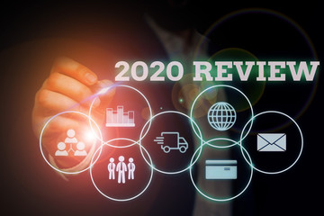 Handwriting text writing 2020 Review. Conceptual photo seeing important events or actions that made previous year Male human wear formal work suit presenting presentation using smart device