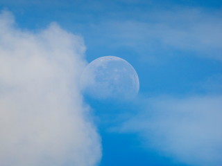 view morning of full moon 70% falling around with white clouds and blue sky background.