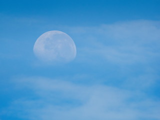 view morning of full moon 70% falling around with white clouds and blue sky background.