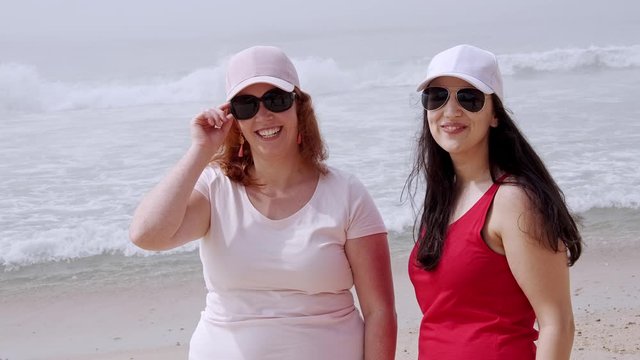 Young women have a great time at the oceanfront - beach vacation - slow motion shot