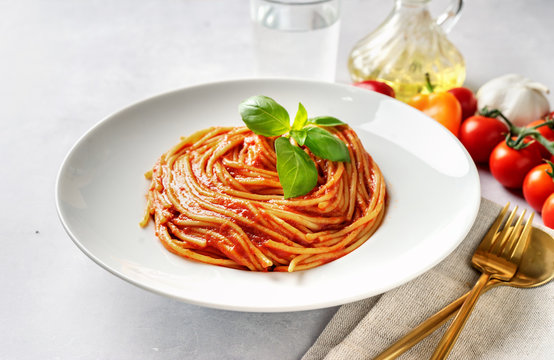 Spaghetti With Tomato Sauce And Basil On White Background