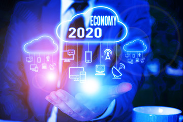 Writing note showing Economy 2020. Business concept for State of wealth and resources of a country in upcoming year Male wear formal work suit presenting presentation smart device