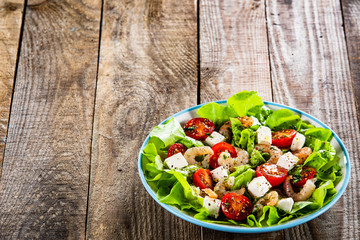 Salad with shrimps and feta cheese on wooden table