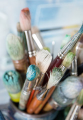 Künstlerpinsel in einem Glasgefäß im Atelier
