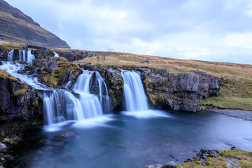 Iceland timelapse photography of waterfall and famous mountain. Kirkjufellsfoss and Kirkjufell in northern Iceland nature landscape