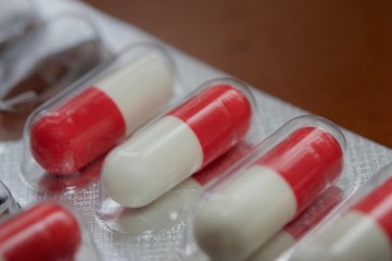 Medication capsules in macro view and dark brown background