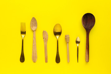 Spoons and forks on yellow background