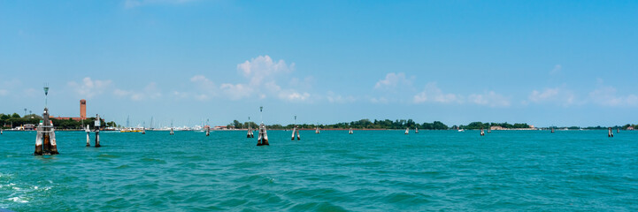 Obraz premium Venice. Island Lido. Panoramic view of beautiful Venetian lagoon. Yachts on the horizon on blue sky background. Header. Banner. 
