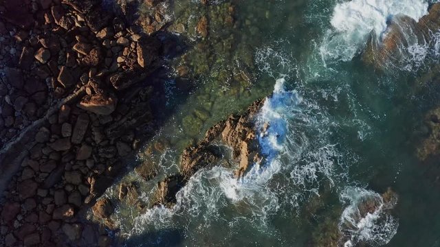 Rolling ascencing shot over sea waves breaking in the reefs and coast, Cantabrian sea, Spain - drone aerial view