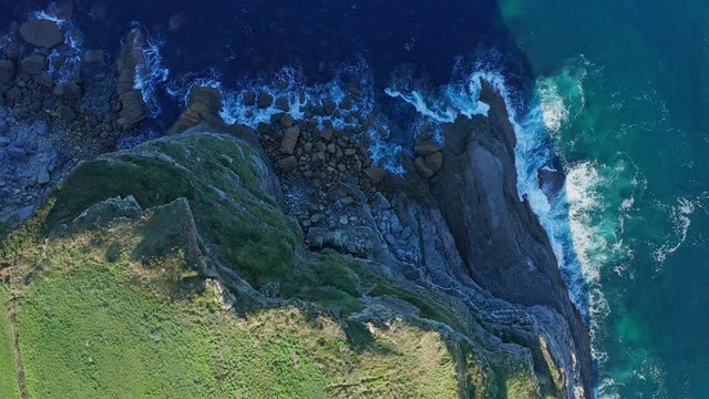 Static shot over sea waves breaking in the reefs and coast, Cantabrian sea, Spain - drone aerial view