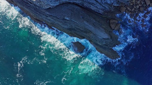 Static shot over sea waves breaking in the reefs and coast, Cantabrian sea, Spain - drone aerial view