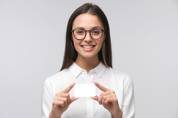 Beautiful smiling woman in white shirt holding and showing blank empty card