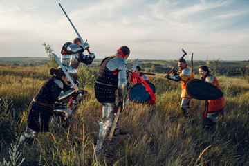 Medieval knights fight with sword and axe