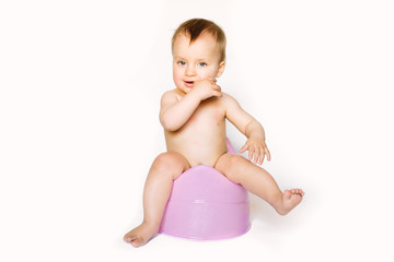 baby girl on chamber pot look on the floor. isolated on white background