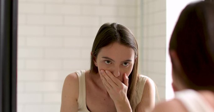 Young woman feels nauseated at home white background