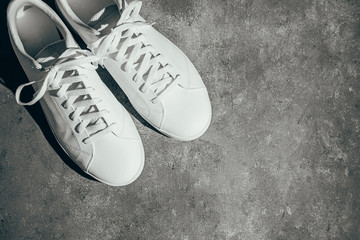 White sneakers on gray background. Stylish white sneakers