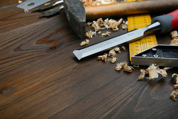 carpenter's background with copy space. carpentry tools: chisel, hammer, building square with wood shavings on a wooden surface. pattern for craft wood workshop