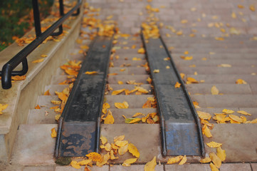 Metallic stage to gate of building. Red ramp equipment on stairs. Walking up and down on stairs....