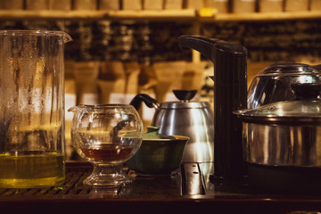 Few lemonade pitchers, kettle and oval glass, during the coffee festival. blurry background