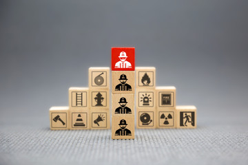 Wooden block with Firefighter icon for fire and safety Concept.