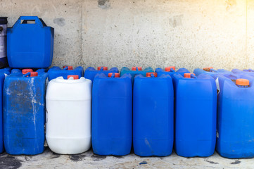 Group oil barrels or chemical of blue plastic gallons,Blue plastic container size 30 liters on the cement floor in the ware house.
