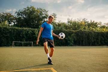 Male soccer player stuffs the ball with his foot
