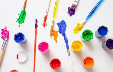 Colorful finger paints set on white color background, top view
