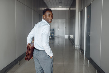 Black businessman with briefcase in office hall