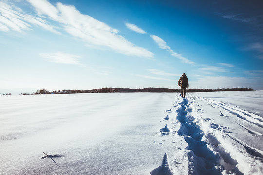 Man Walking In Snow Footprints