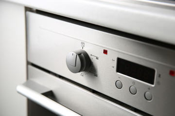 Round knob on a silver electric oven close up