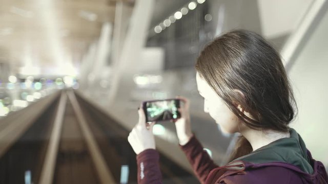 Woman against Front Window at Inter Terminal Train. Caucasian Girl Sit at Automatic Airport Shuttle. Passenger make Video from Driverless Transport. Arrival Departure Passage. Footage Shot in 4K