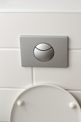 toilet flush button hanging on the wall in the bathroom of the hotel house with white tiles white. Bathroom luxury interior. 