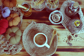 woman hand hold coffee cup on autumn background with decor seasonal ornament table