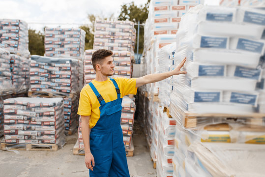 Male builder at the pallets of building materials