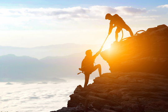 Climbing Team Are On The Climb To The Cliff,hiking And Team Work Concept.    Mountaineer Climbing A Steep Cliff.